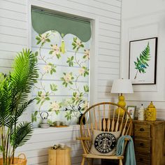 a room with white walls and green plants on the window sill next to a chair