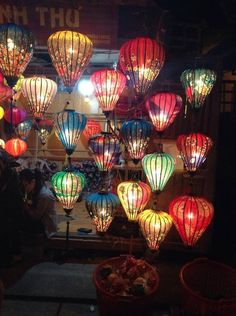 many colorful lanterns are lit up in the dark