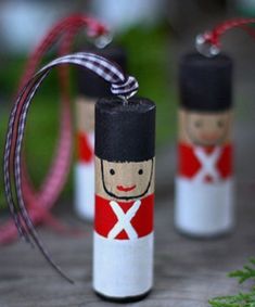 two small bottle ornaments are sitting on a table with red and white ribbon around them