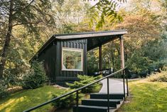 a small cabin in the woods with stairs leading up to it