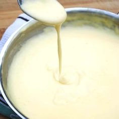 a spoon is pouring batter into a pan