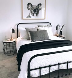 a bedroom with a bed, nightstands and pictures on the wall above it in black and white