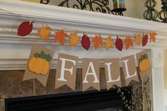 an autumn banner hanging from a fireplace mantel