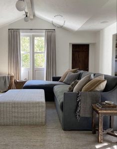 a living room filled with furniture next to a window and a rug on the floor