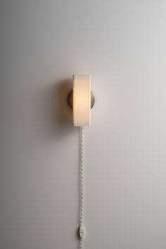 a white wall mounted light on a gray wall