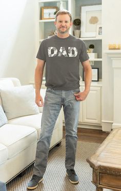 a man standing in front of a couch wearing a t - shirt that says idaho