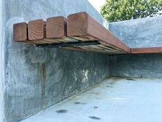 a wooden bench sitting on top of a cement wall