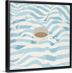 a cup of coffee sitting on top of a blue and white wave pattern framed canvas