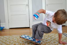 a young boy riding a skateboard on top of a wooden floor next to a door