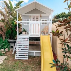 a small house with a slide in the yard