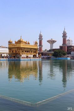 a large body of water in front of some buildings with towers on each one side