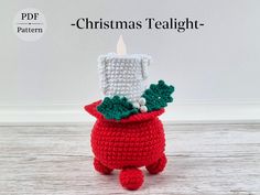 a crocheted christmas tealight holder sitting on top of a wooden table next to a white wall