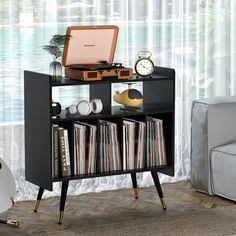 a record player is sitting on top of a shelf with records and cds in front of it