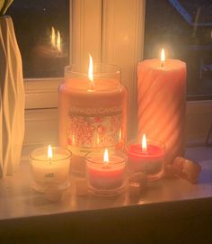 some candles are sitting on a window sill