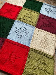 a crocheted blanket is laying on the floor with it's squares in different colors