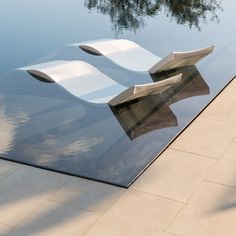 the reflection of trees in the water is seen on the glass top of a sculpture