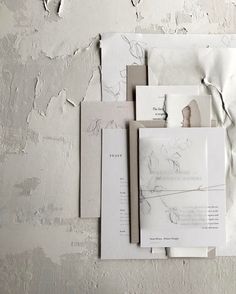 several pieces of torn up paper sitting on top of a white wall with peeling paint