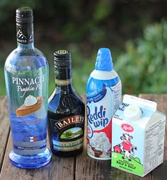 the ingredients to make an ice cream sundae are displayed on a wooden table outside