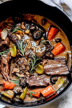 a pot filled with meat and vegetables on top of a table