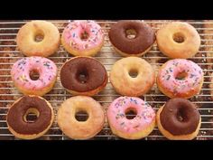 a bunch of doughnuts that are sitting on a cooling rack with sprinkles