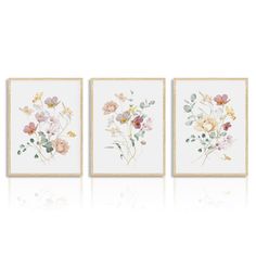 three framed paintings with flowers on them, one is white and the other is pink