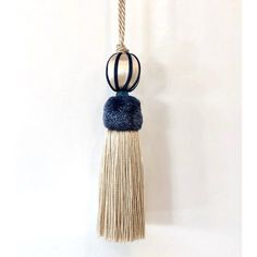 a blue and white tasselle hanging from a rope with two black rings on it