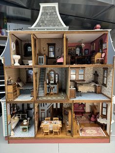 a doll house with furniture and accessories on display