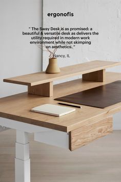 a wooden desk with a laptop on it and a quote about ergonofits