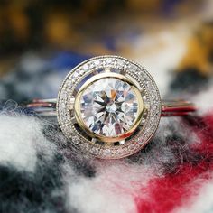 a diamond ring sitting on top of a pile of wool