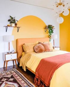 a bedroom with yellow walls and orange bedding