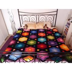 a bed with a colorful quilt on top of it