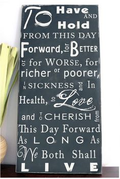 a black and white sign with words written on it next to a vase filled with flowers