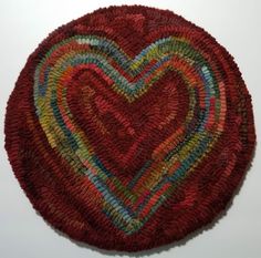 a red heart shaped rug on top of a white wall