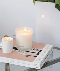 a white candle sitting on top of a book