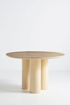 a round wooden table with three columns on each side