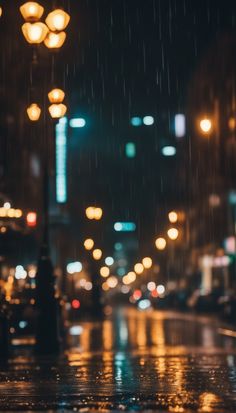 rain is falling down on the street at night