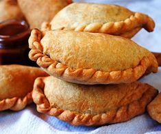 several pastries stacked on top of each other with dipping sauce in the back ground