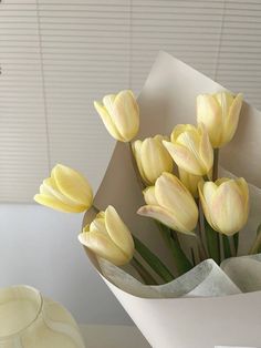 a bouquet of yellow tulips sitting on top of a table