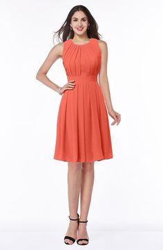 a woman in an orange dress posing for the camera with her hands on her hips