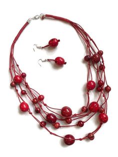 Red Tagua Bib Necklace Ecuadorean Tagua Jewelry - Eco Friendly Part Number: TAG707 Item Weight: 1.15oz Product Length: 24 inches long Earrings Length: 2 inches About Tagua This Product is handcrafted from a palm tree nut native to the lush tropical rainforests of Ecuador. Also referred to as the Ecuadorean Ivory Palm, the Tagua tree produces several bushels of seed pods a year with up to 100 Tagua nuts per pod. These nuts are then harvested, dried, and crafted into a wide range of products from Red Beaded Dangle Necklace, Red Wooden Beads Round Necklace, Red Necklace With Wooden Beads, Multi-strand Necklace With Red Wooden Beads, Multi-strand Red Necklace With Wooden Beads, Red Multi-strand Necklace With Wooden Beads, Red Wooden Beads Jewelry As A Gift, Red Wooden Beads Jewelry For Gift, Red Wooden Beads Jewelry Gift