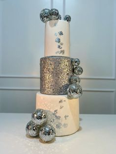 a three tiered cake with silver decorations on top