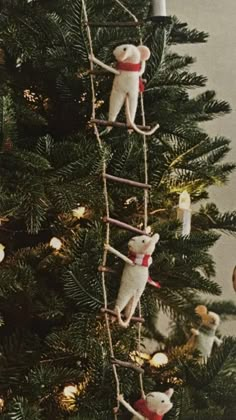 a christmas tree with two mice climbing the ladder