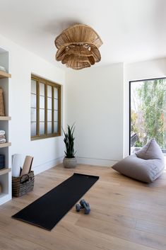 a yoga mat is on the floor in front of a large window with an open door