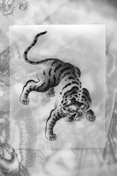 a black and white photo of a tiger in the middle of a painting with an octopus on it's back