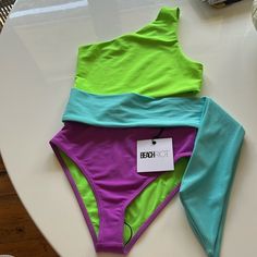 Nwt Beach Riot, Carli One-Piece Swimsuit, Never Worn, Xs. Color Is Neon Green, Purple, And Blue. Purple One-pieces For Poolside And Beach Season, Purple One-piece Swimwear For Summer Beach, Purple One-piece Swimwear For Beach, Playful Purple Swimwear, Purple One-piece Beachwear Swimwear, Beach Riot, Woman Beach, Neon Green, Green And Purple