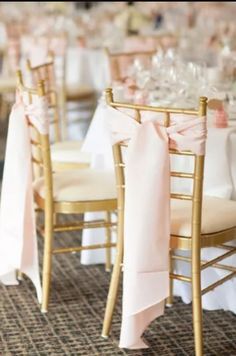 the tables are set up with white linens and pink sashes on each chair