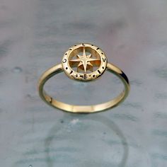 a gold ring with a compass on it