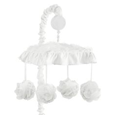 a white baby crib mobile with flowers hanging from it's sides and a button on the top