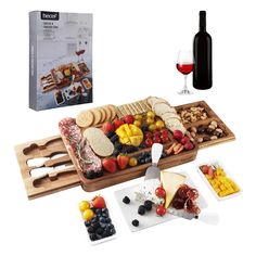 an assortment of cheeses, fruit and crackers on a serving tray with a bottle of wine