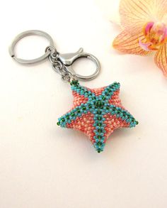 a star shaped beaded keychain sitting next to a flower